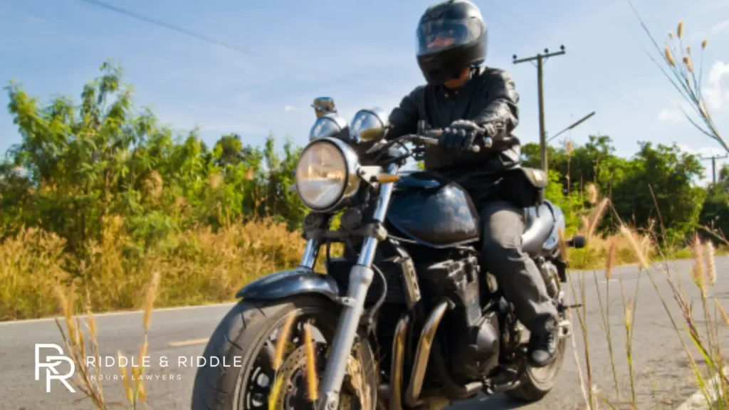 A man ridding a motorcycle with helmet and gloves on