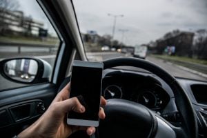 Person using a smartphone while driving - Riddle & Brantley