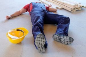 Construction worker lying on the ground after an injury - Riddle & Brantley