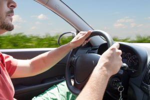 Side view of a person driving their car. 