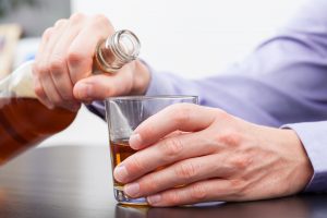 Foto de un hombre con una botella en la mano