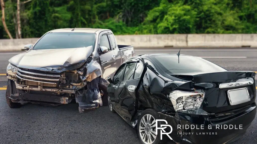 A silver and black car colliding head on