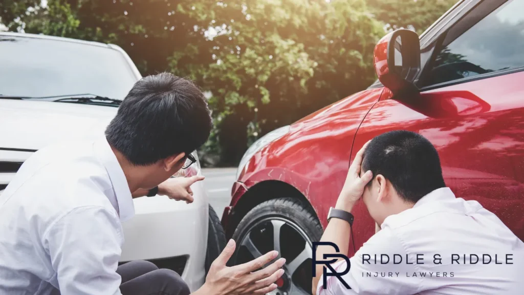 two people outside their car after an accident while one of the drivers is experiencing anxiety and PTSD
