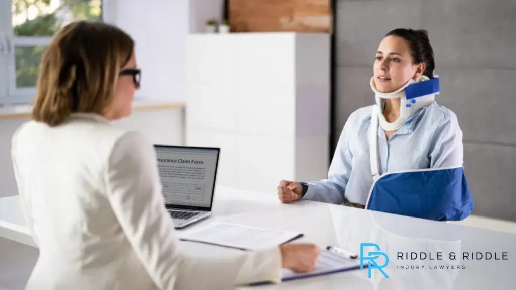 Woman sitting at a lawyers desk going over her workers compensation claim