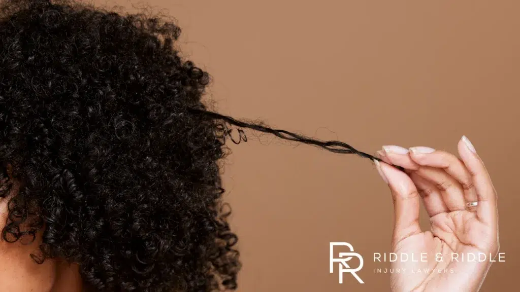 A hand pulling strands of curly hair
