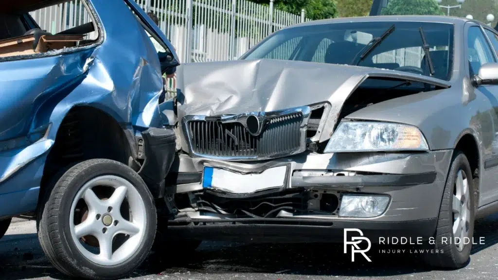Silver car with massive front-end and side damage after a serious collision