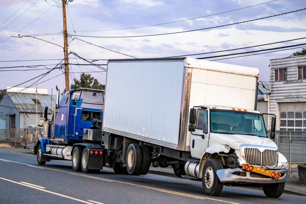 Mobile blue roadside assistance powerful tow big rig semi truck tractor towing broken after accident