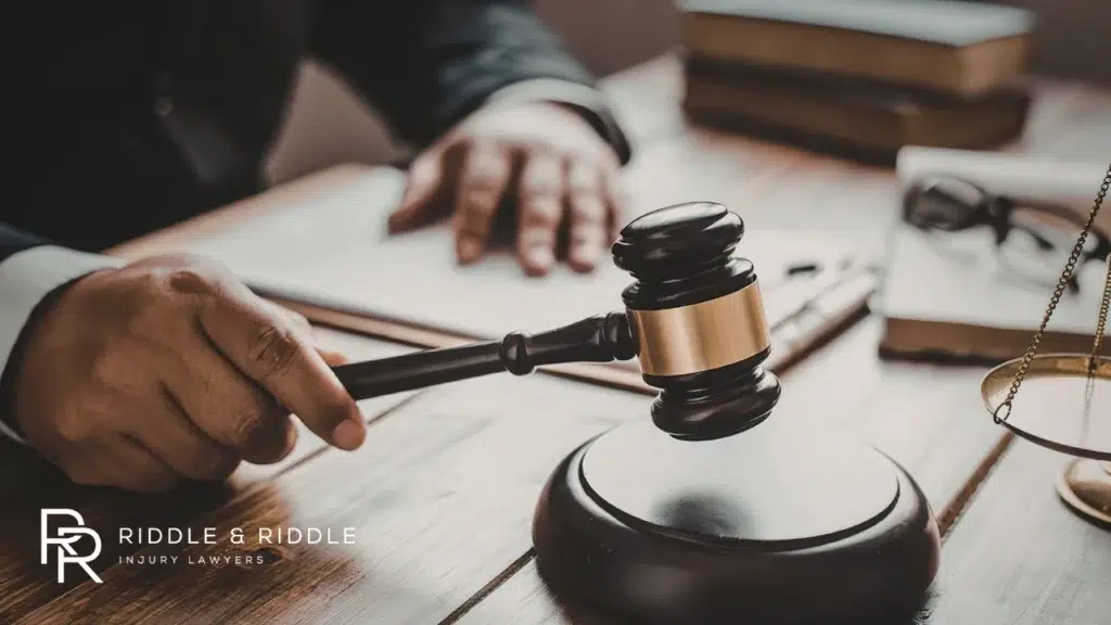 Close-up of a wooden judge’s gavel resting on a desk with legal papers in the background