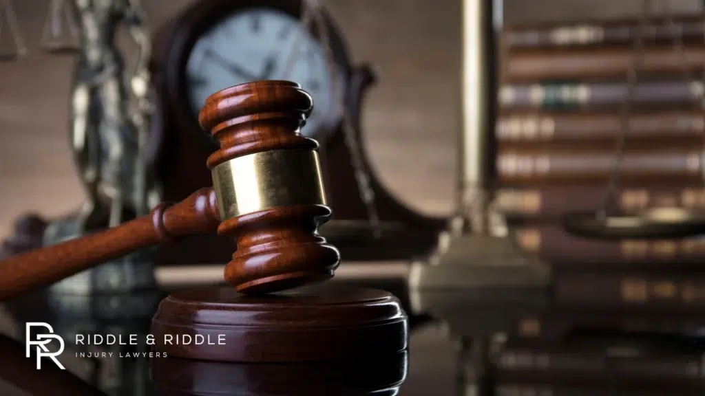 A judge’s gavel resting on a book with the scales of justice blurred in the background