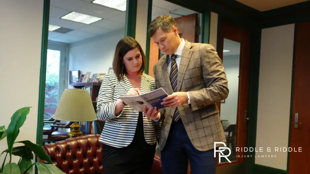 Gene Riddle and paralegal looking at documents together