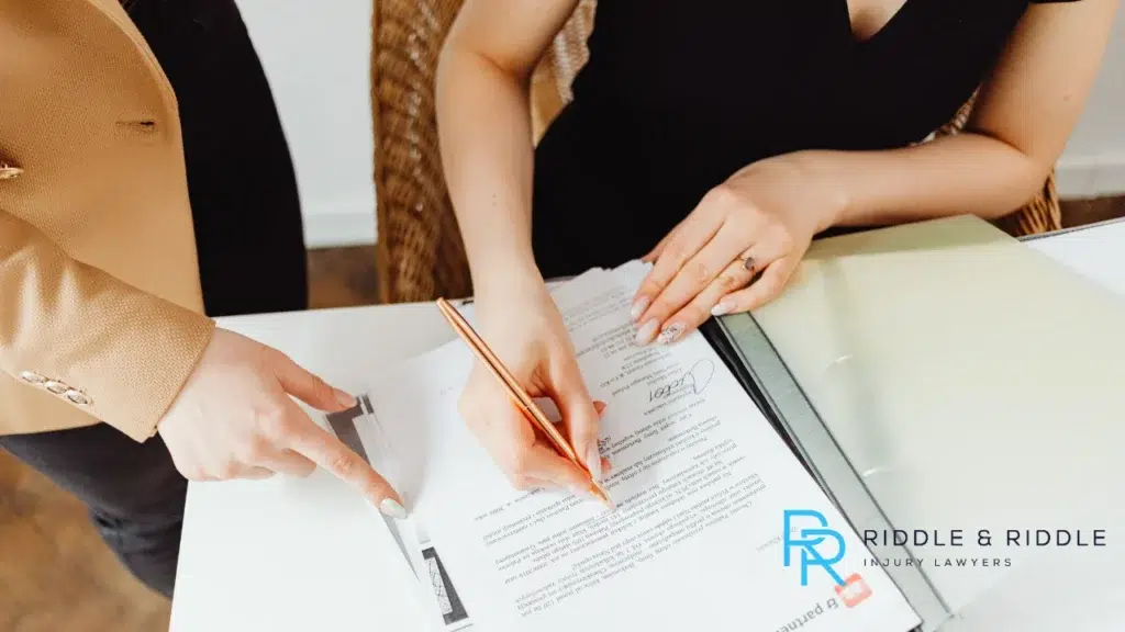 Two women looking at a legal document, with one of them signing it