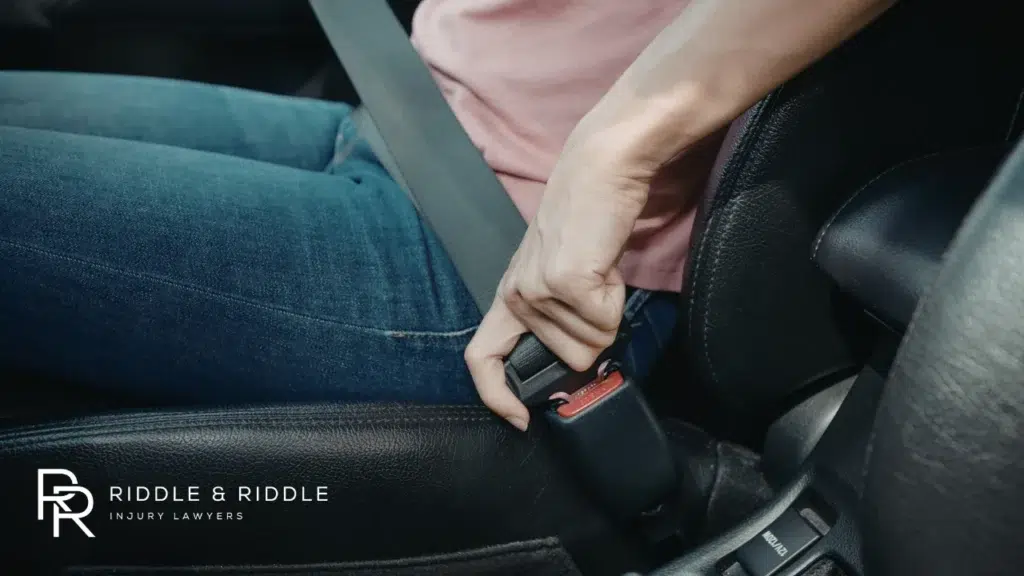 Close-up shot of a person clicking their seatbelt into the buckle inside a car
