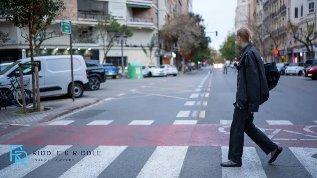Tall blonde woman crossing the street using the crosswalk