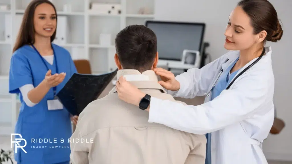 Doctor and nurse examine a patient wearing a cervical neck brace in a clinic