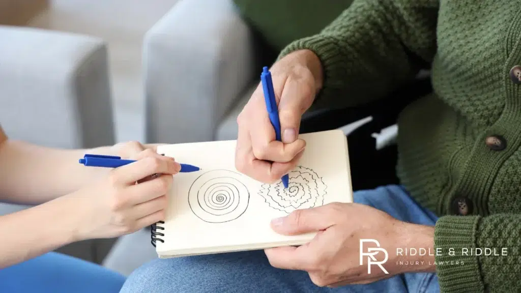 Person uses a blue pen to draw concentric circles on a notepad held by another person