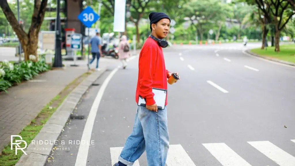Teenager crossing the road using crosswalk