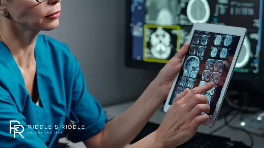 Doctor in blue scrubs examines MRI brain scans on a tablet