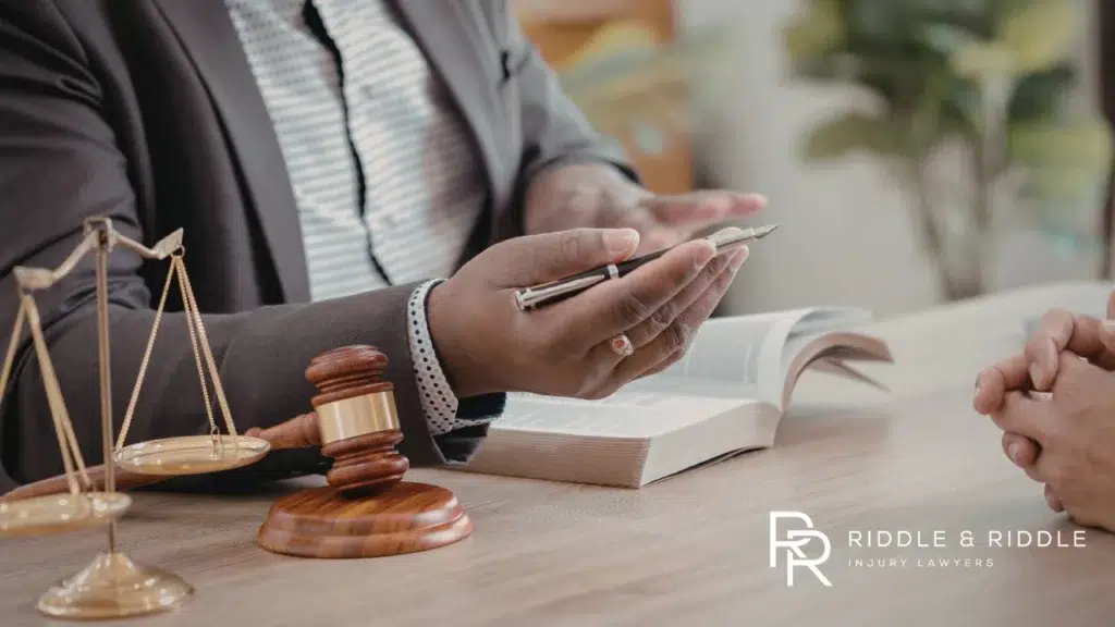 Close-up of a person in a suit reviewing documents next to a gavel and scales