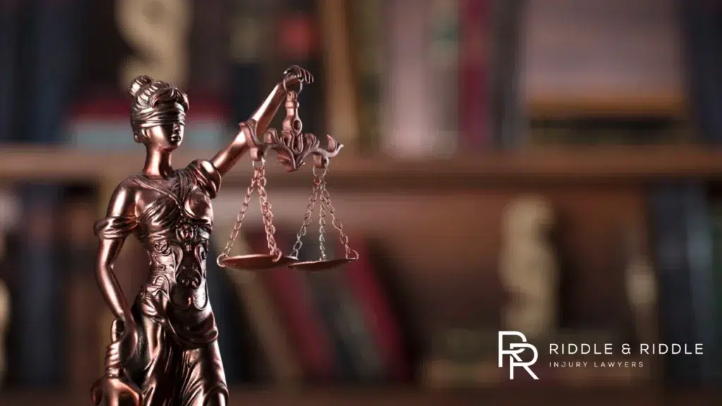 A bronze statue of Lady Justice holding scales, symbol of the legal system