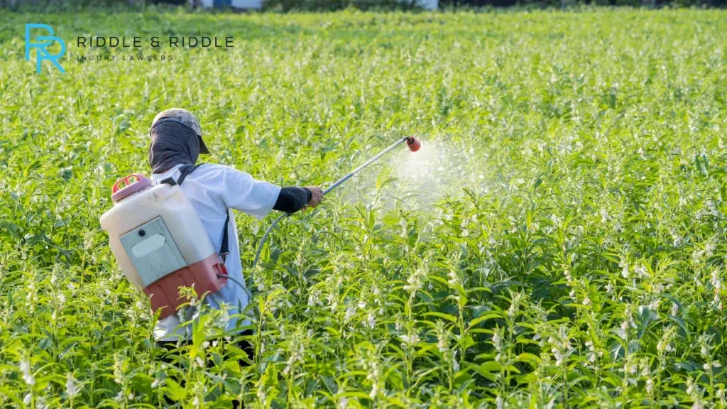 worker spraying chemical water on plants