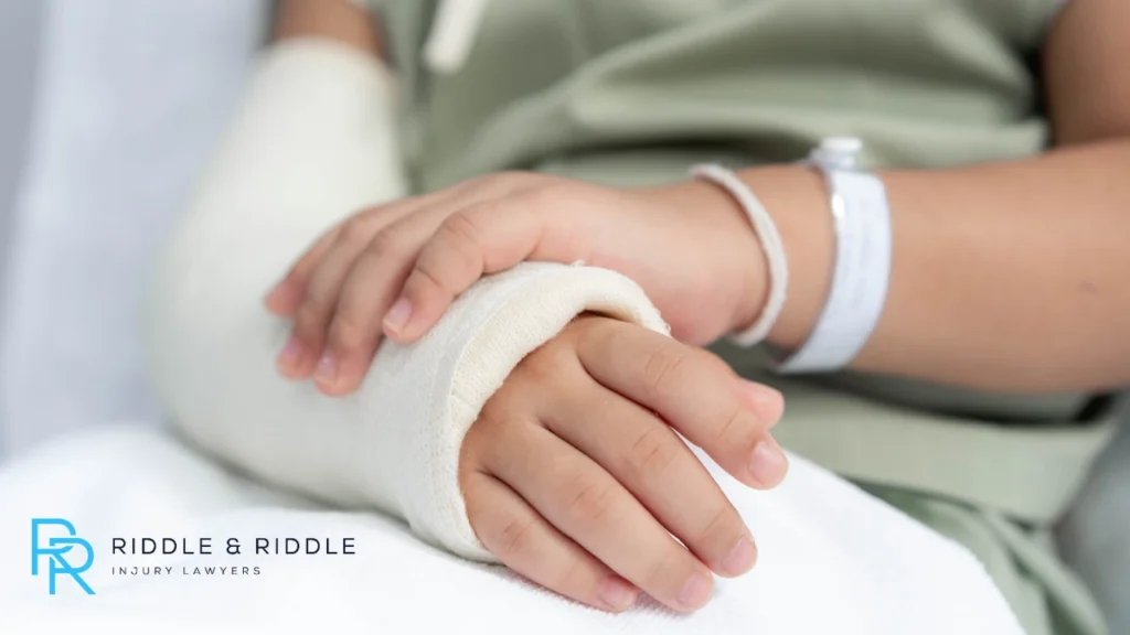 Person holding their broken arm