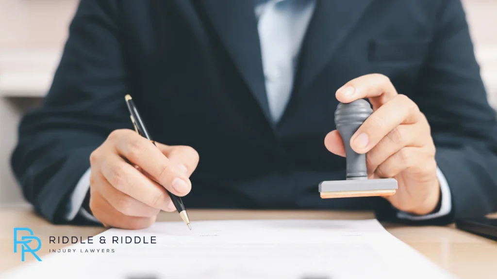 Person wearing a suit writing and stamping a paper