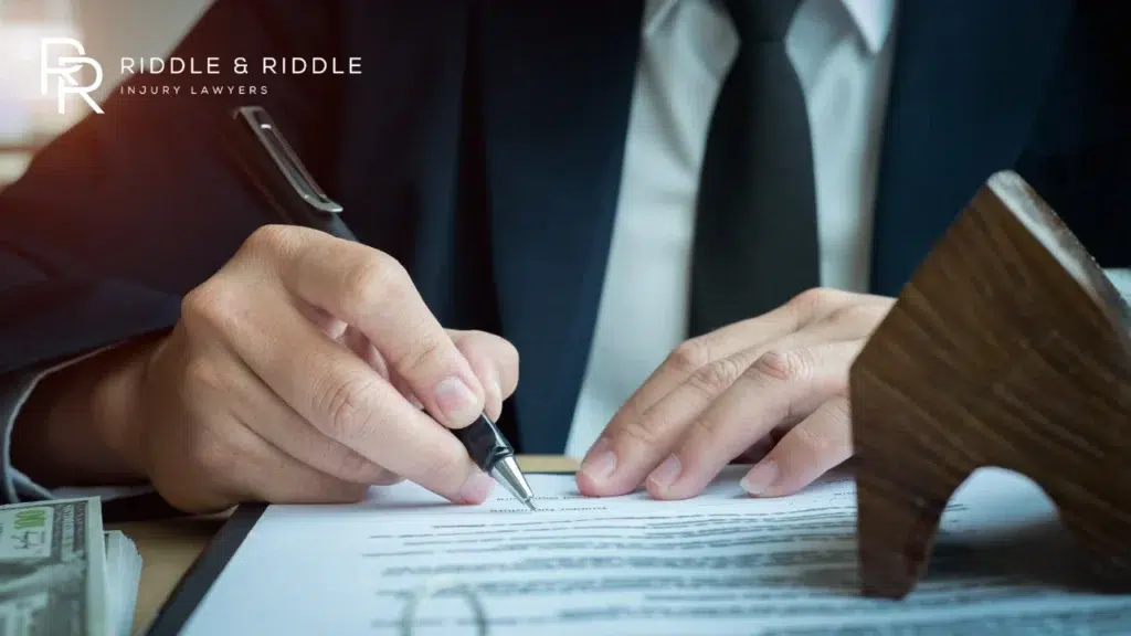 Close-up of a person in a suit and tie signing a legal document with a fountain pen