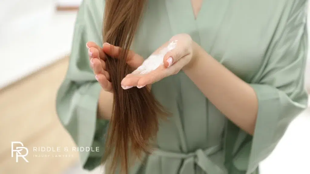 Woman applies a white powder to her long brown hair
