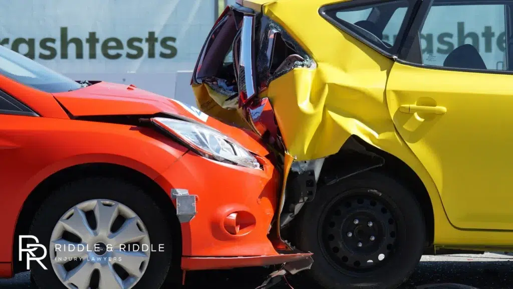 An orange car and a yellow car smashed together in a broadside collision