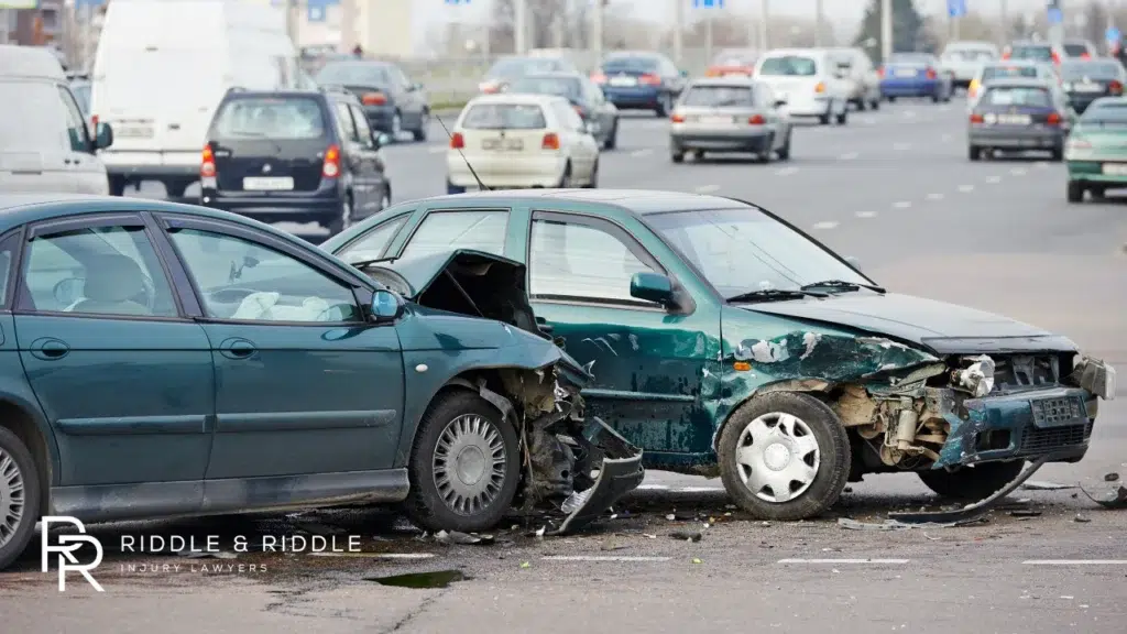 Two dark sedans crashed head-on with debris scattered across the road