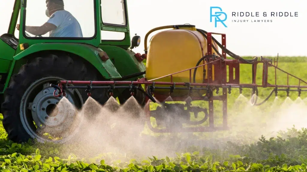 Worker driving machinery and spraying water on plants