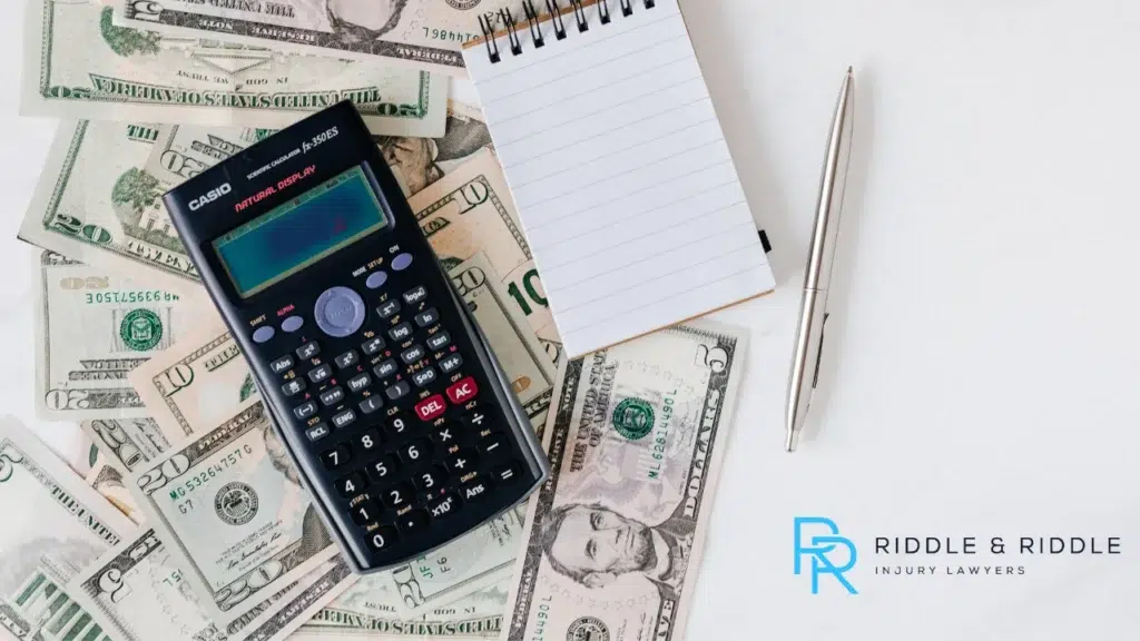 Close-up image of money, calculator and pen and paper
