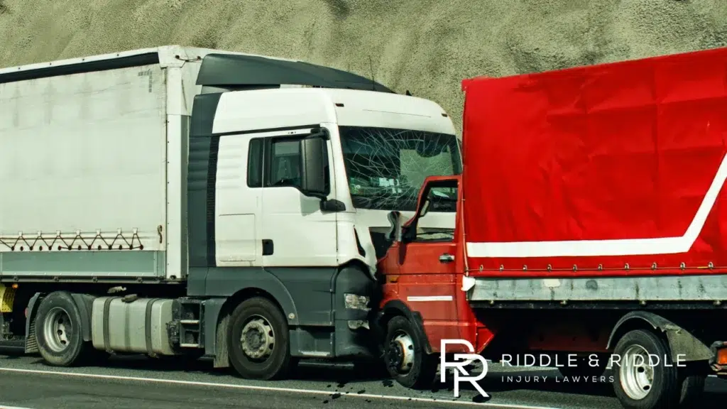Bright blue semi-truck with chrome grille driving on a foggy mountain highway road