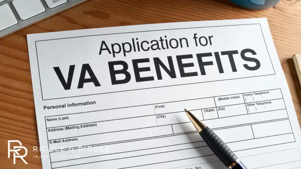 VA Benefits application form with a pen